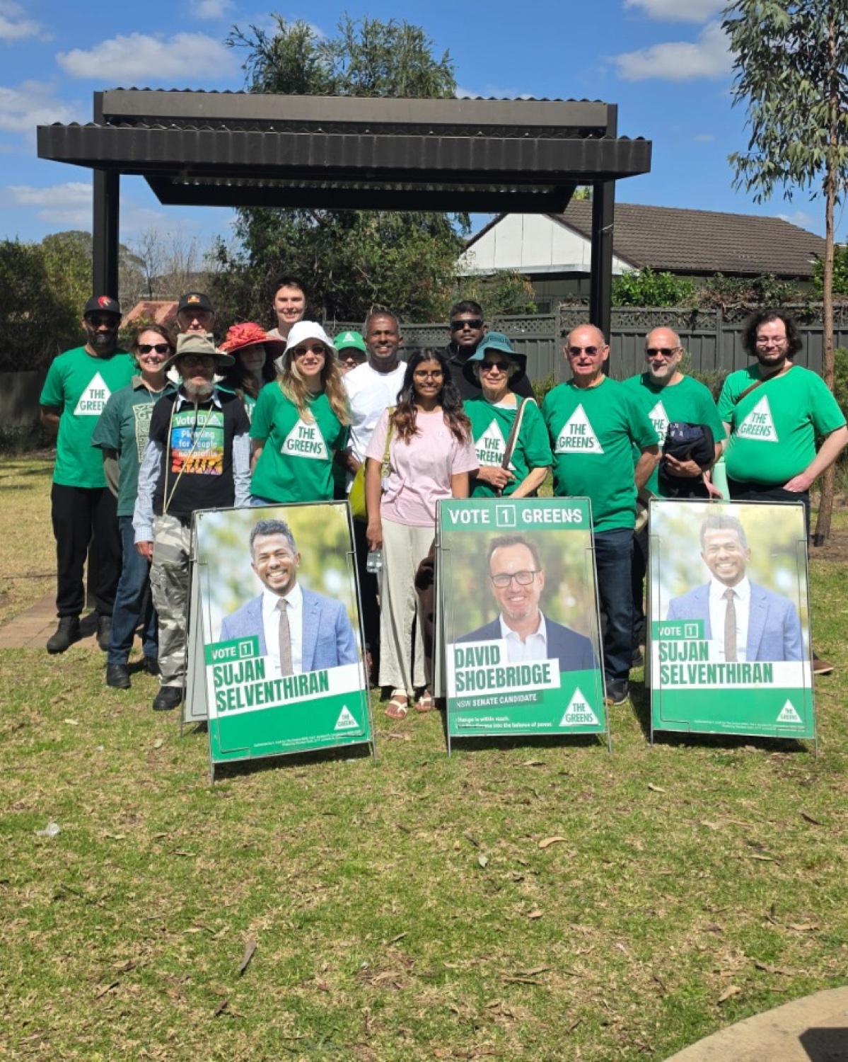 Greens volunteers with Sujan Selven campaign signs at a local community stall